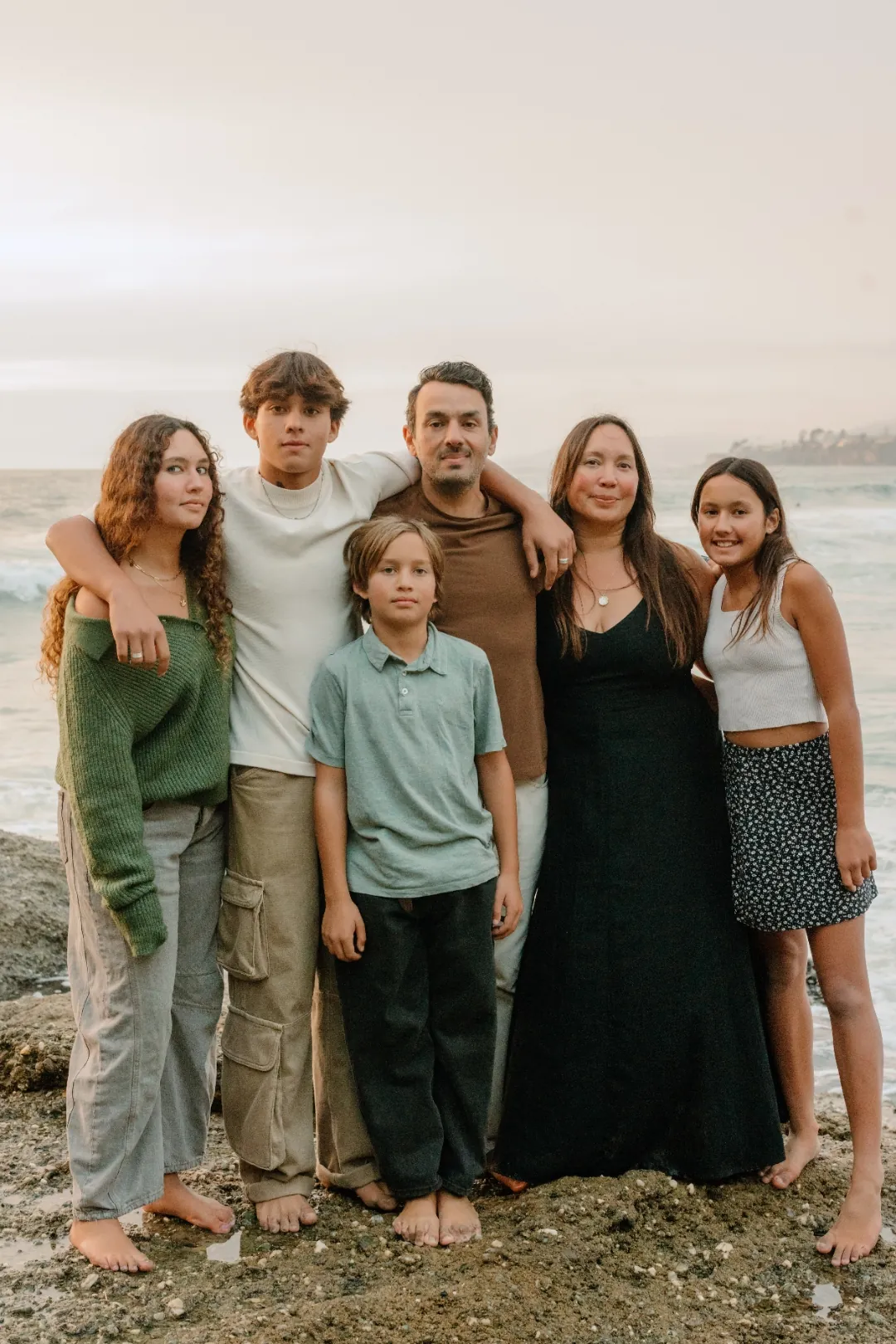 Melissa Awad with her husband and their four children by the ocean at dusk.